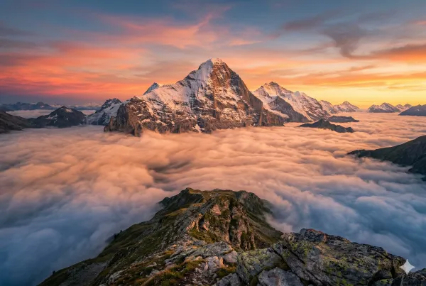 Mountain peaks above clouds at sunset